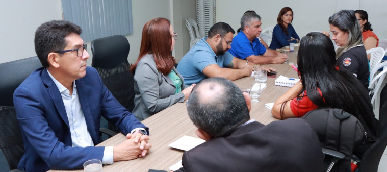 Reunião com representantes de diferentes setores em torno de uma mesa, discutindo pautas de interesse coletivo.