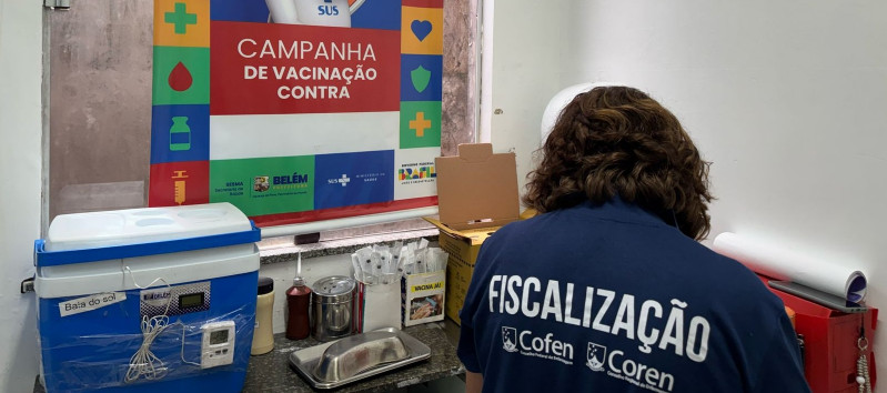 Uma enfermeira fiscal do Coren-PA, vestindo um jaleco azul escuro com a inscrição 